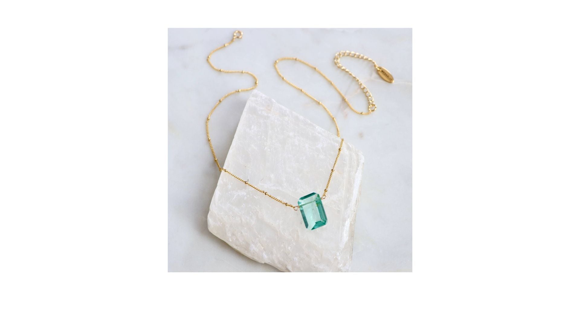 gold chain necklace with light blue gemstone pendant