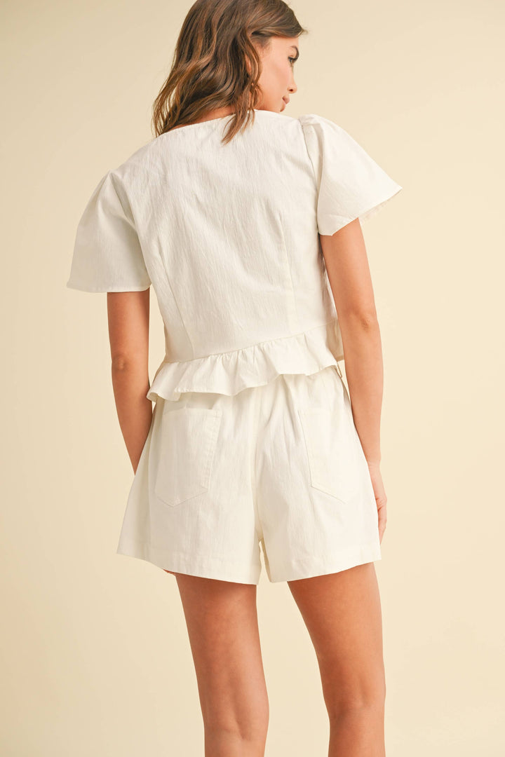 Woman wearing white shorts with back pocket 