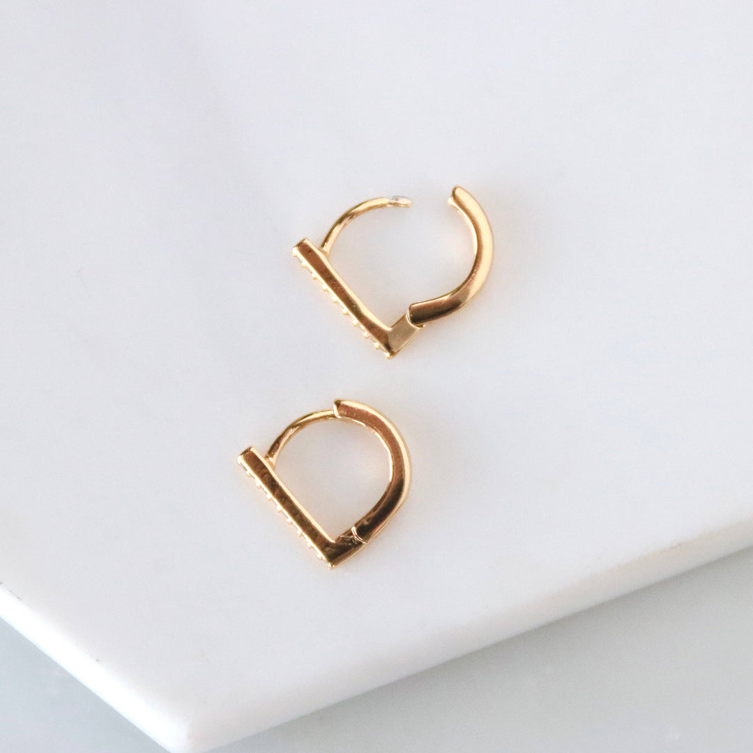 Gold hoop earrings on a light gray background