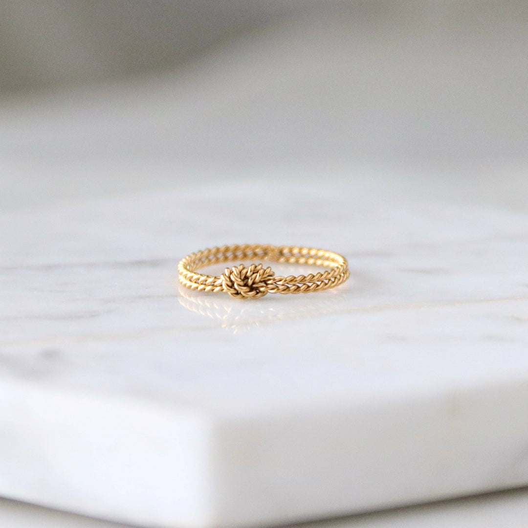 Dainty gold ring on a marble surface