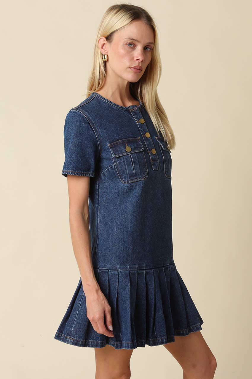 Woman wearing a denim dress against a beige background