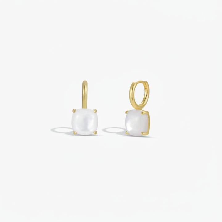 Gold earrings with white gemstones on a white background