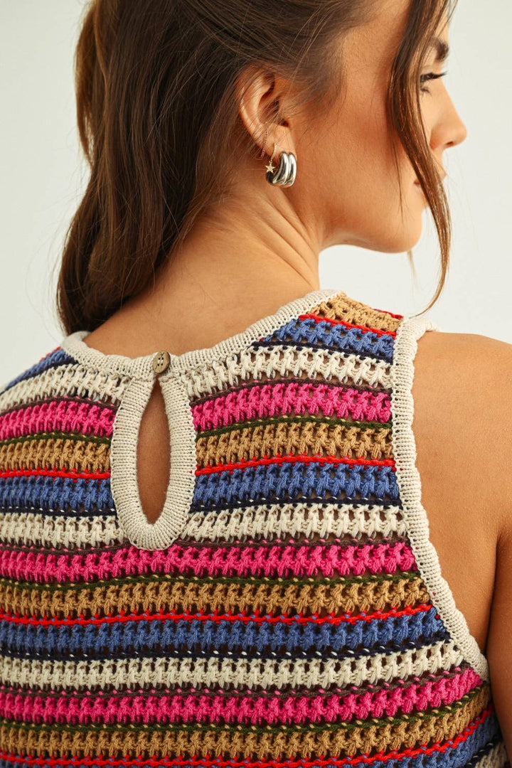 Woman wearing a colorful striped crochet top with a neutral background