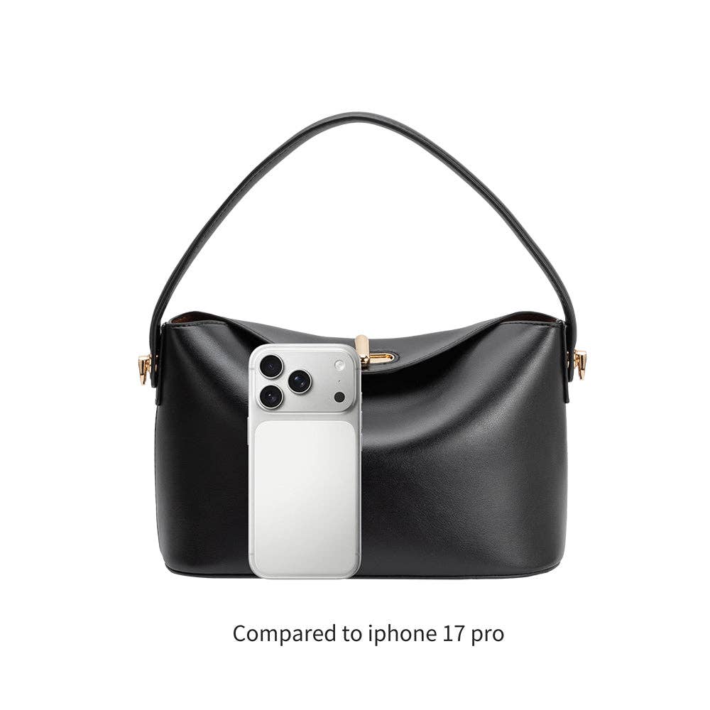 Black vegan leather handbag with a phone inside, compared to an iPhone 17 Pro on a white background