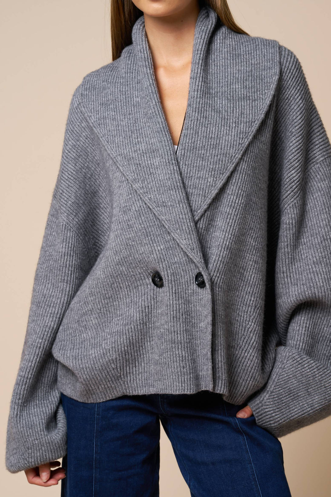 Gray knit wrap cardigan sweater worn by a woman on a beige background