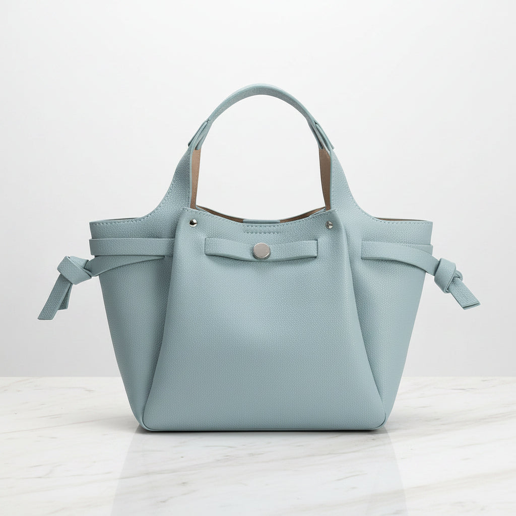 Light blue handbag vegan leather with ribbon details on a white background