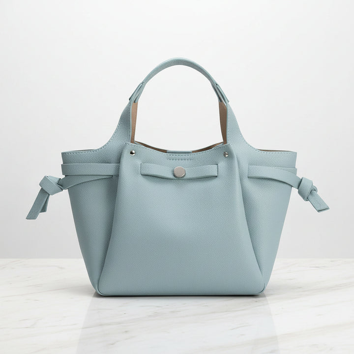 Light blue handbag vegan leather with ribbon details on a white background
