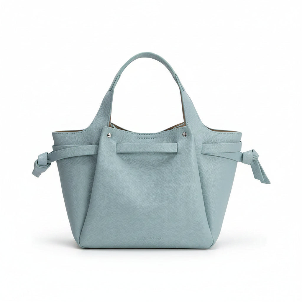 Light blue handbag with bow details on a white background