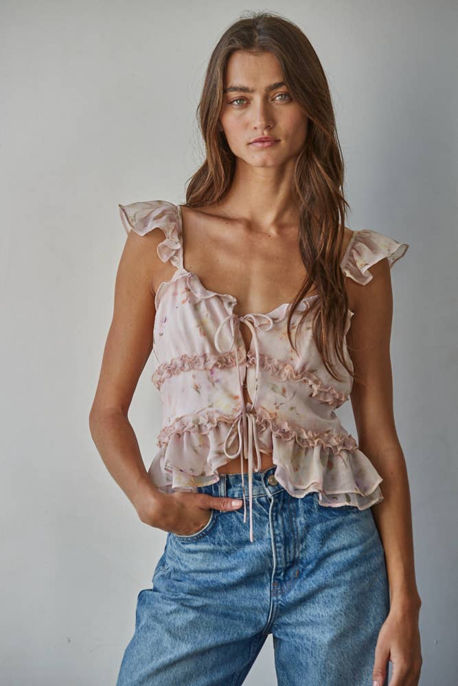 Woman wearing a pink floral top and blue jeans.