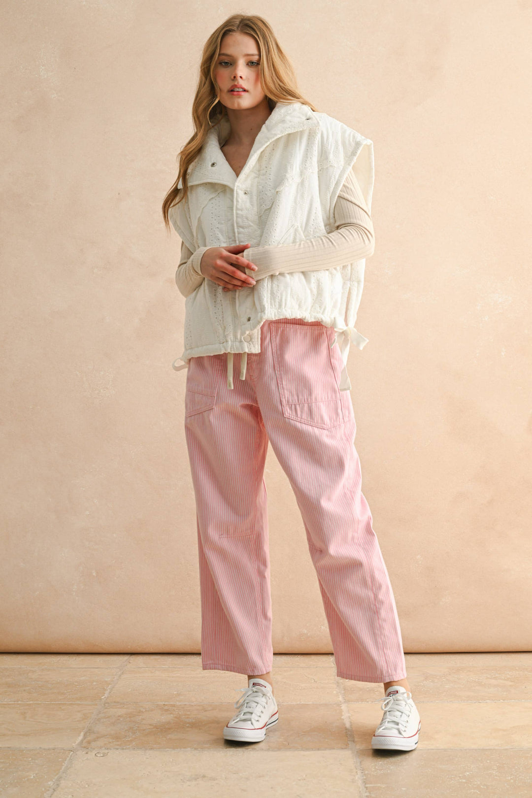 Woman wearing  pink and white striped cropped pants with drawstring