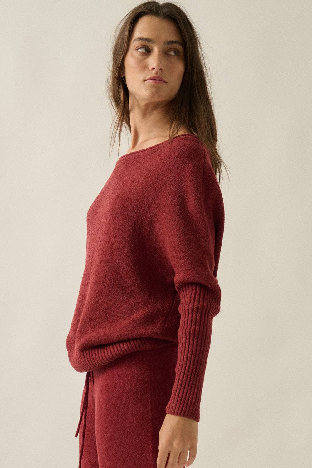 Woman wearing a red sweater against a plain background