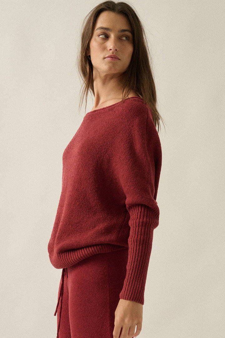 Woman wearing a red sweater against a plain background