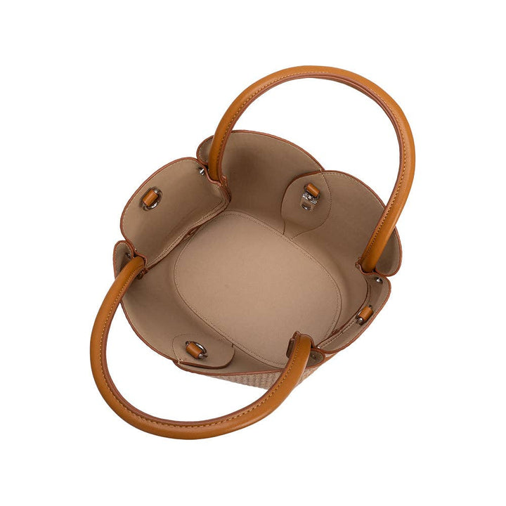 Brown woven raffia handbag with brown handles on a white background