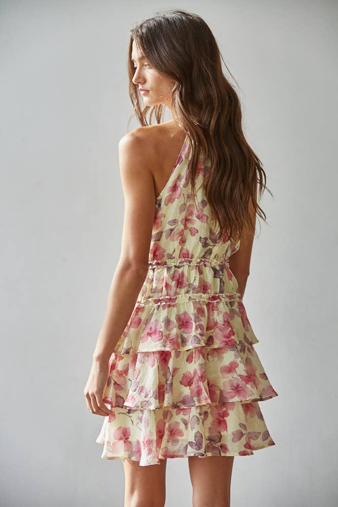 Woman wearing a floral mini dress against a plain background