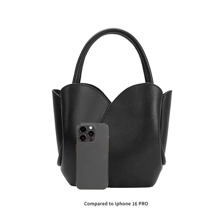 Black handbag with a smartphone inside, compared to an iPhone 16 Pro on a white background
