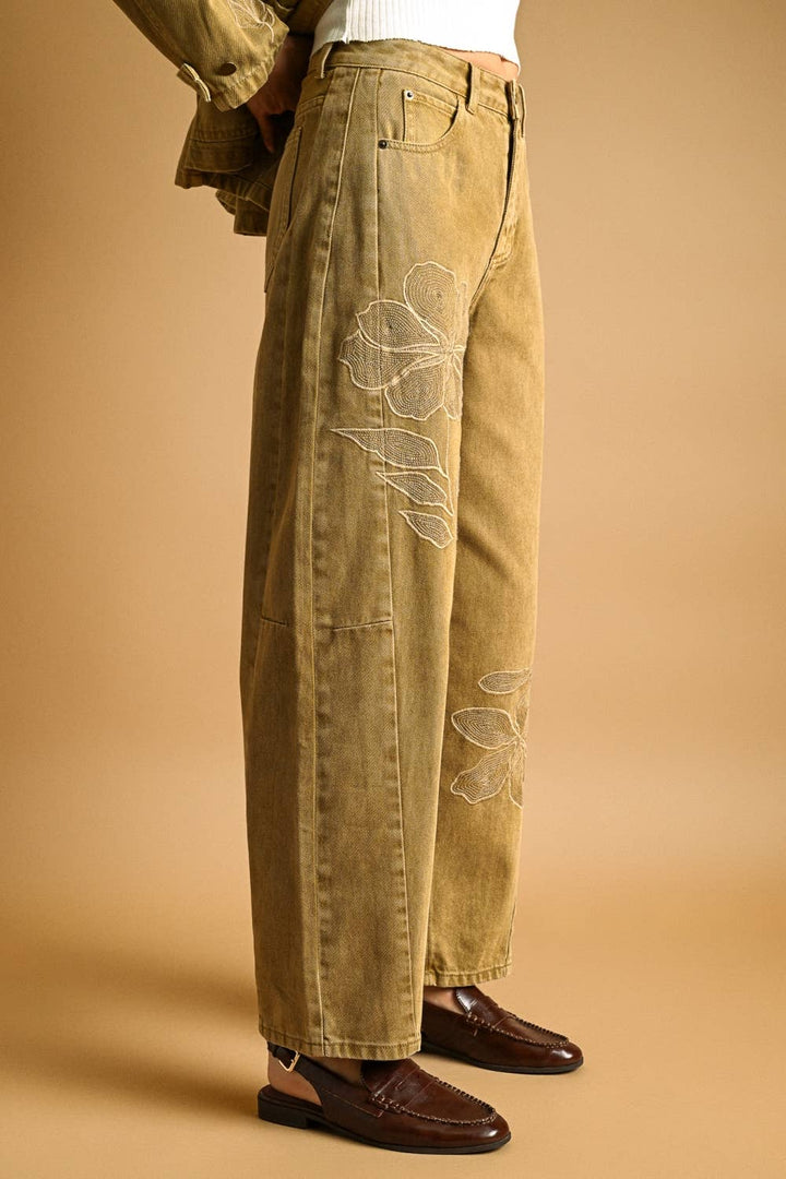 Women's tan barrel pants with floral embroidery on a beige background