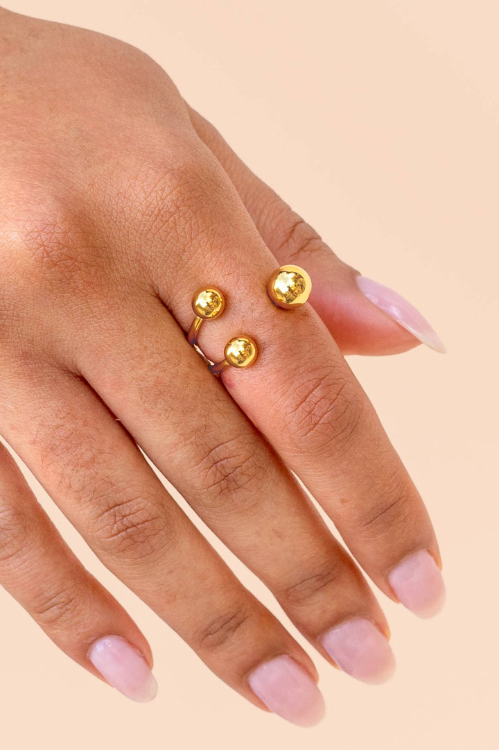 Gold ring ion a hand with a beige background