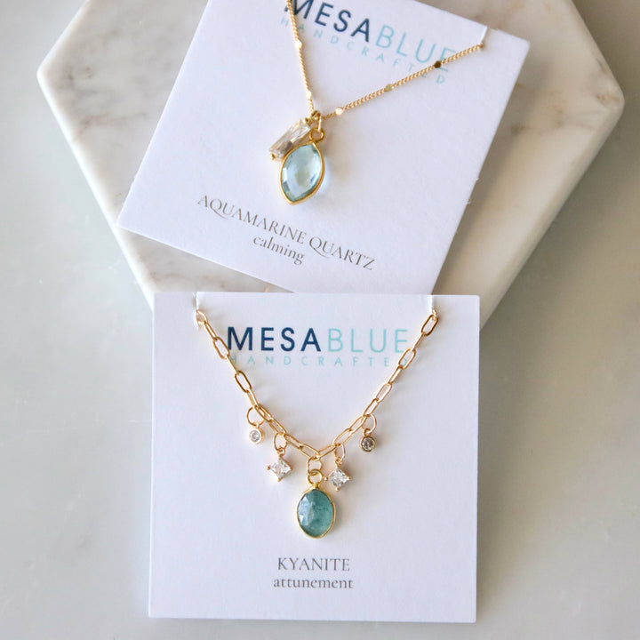 Gold necklaces with gemstones on Mesa Blue display cards