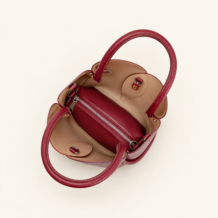 Interior of a top handle bag with burgundy and beige colors on a white background