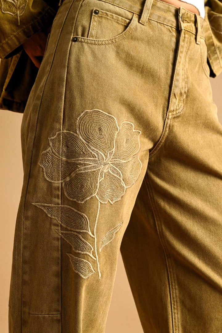 Brown pants with floral embroidery on a beige background