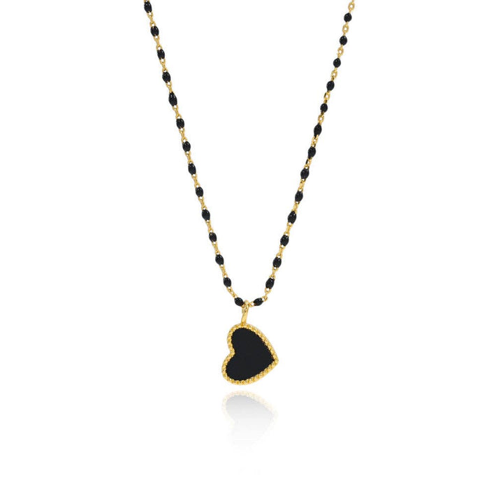 Necklace with black heart pendant and gold chain on a white background