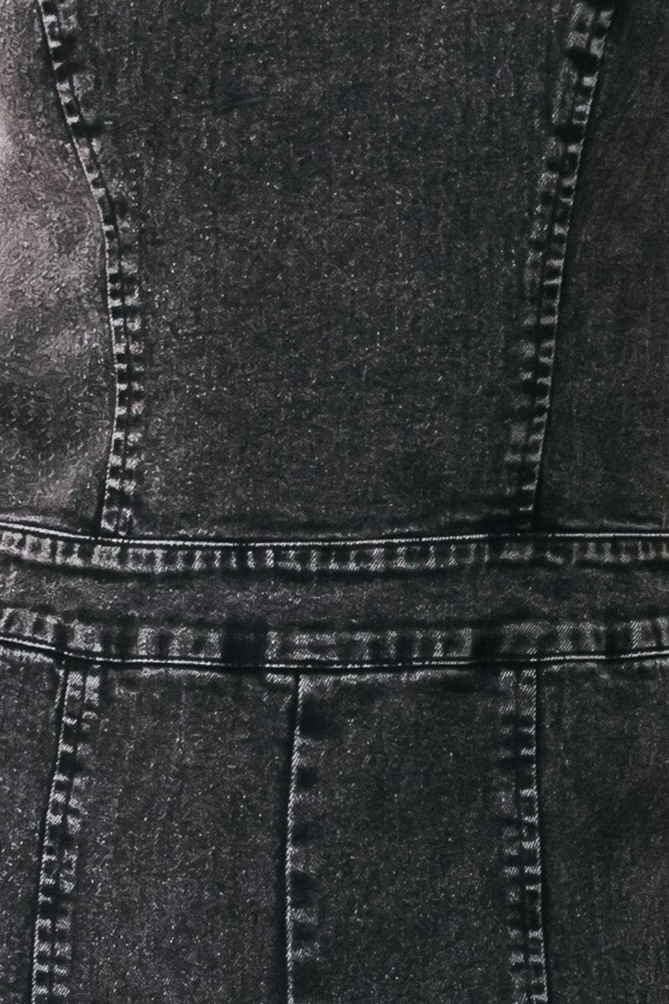 Close-up of a dark gray or black denim garment showing the fabric texture, seams, and stitching details.