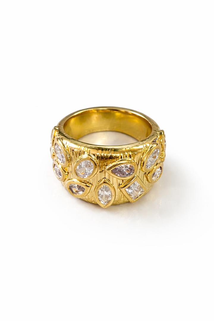 Gold ring with cubic zirconia accents on a white background