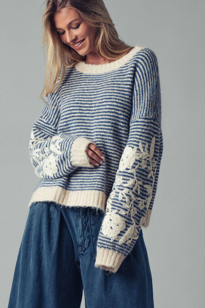 Woman wearing a blue and white patterned sweater with a gray background