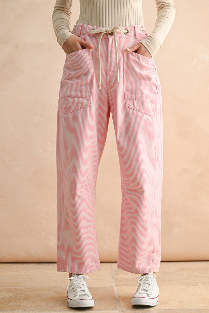 Person wearing pink striped pants drawstring waist and barrel leg 