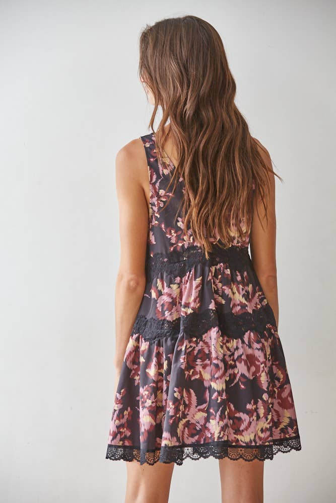 Woman wearing a floral sheath dress with a plain background