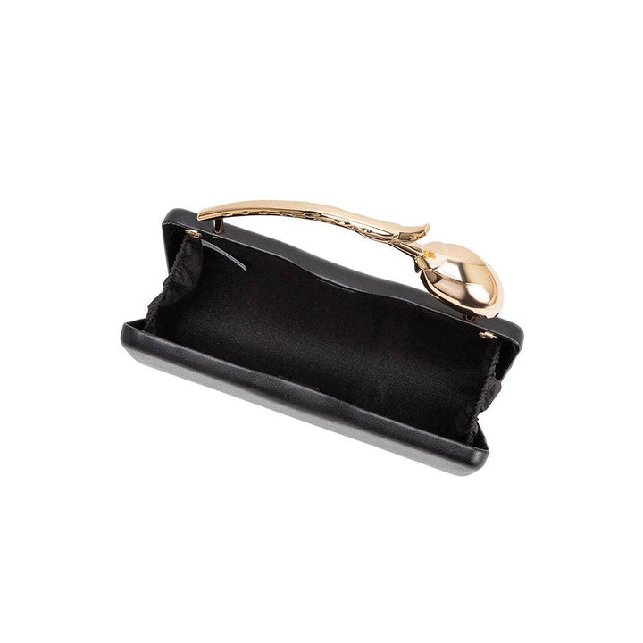 Black faux leather clutch with a gold flower shaped handle on a white background