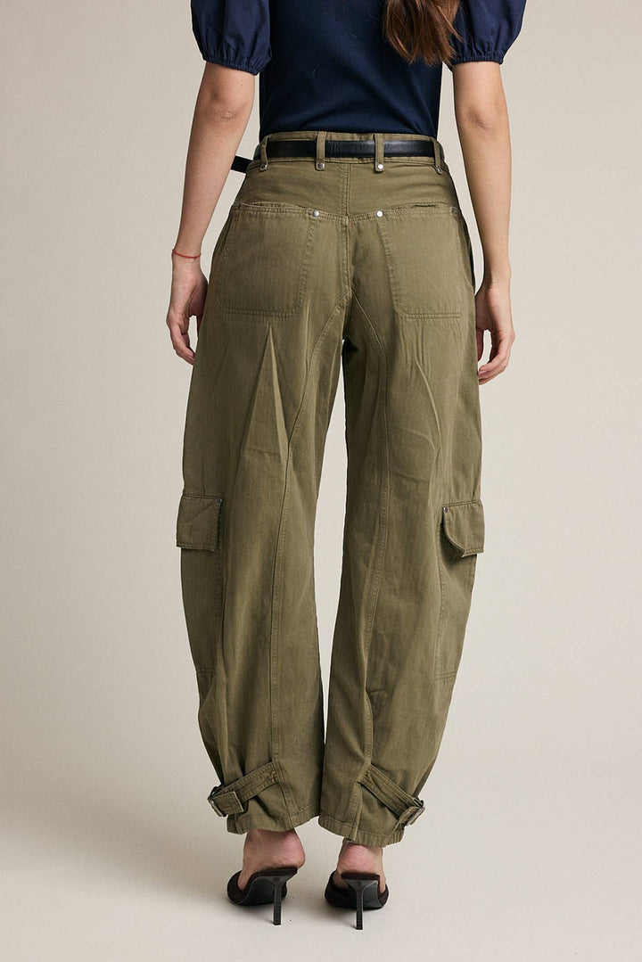 A model is shown from the back wearing olive green wide-leg cargo pants with a black belt, paired with a navy top and black heels, against a neutral beige background.