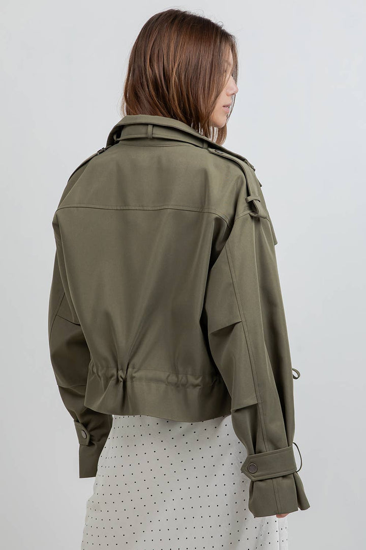 Woman wearing an olive green jacket on a white background