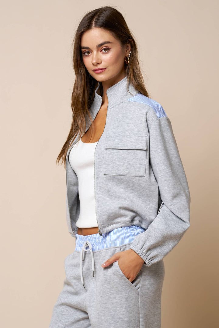 Woman wearing a gray lounge wear matching set outfit with a beige background