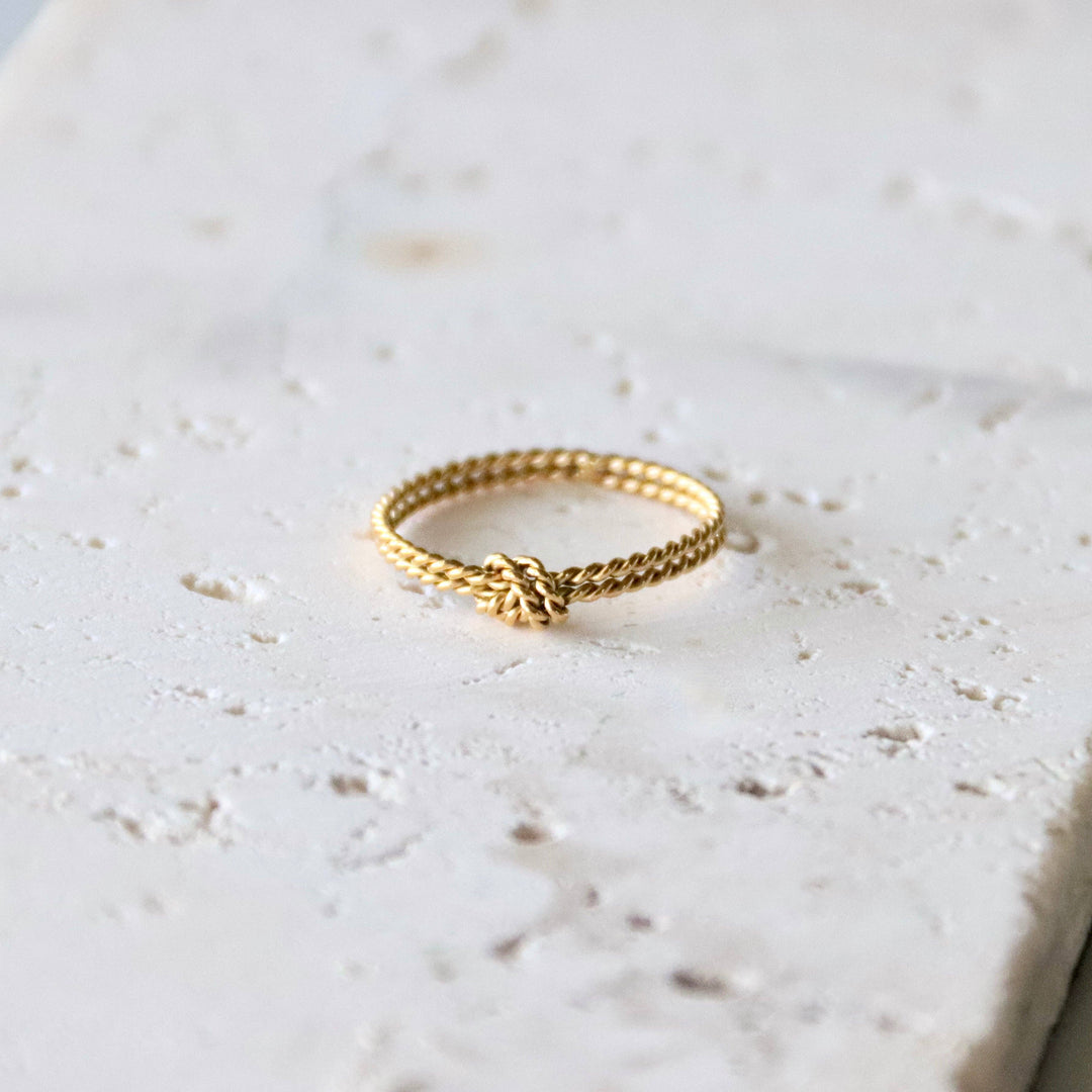 Gold thin ring on a light marble surface