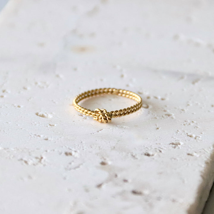 Gold thin ring on a light marble surface