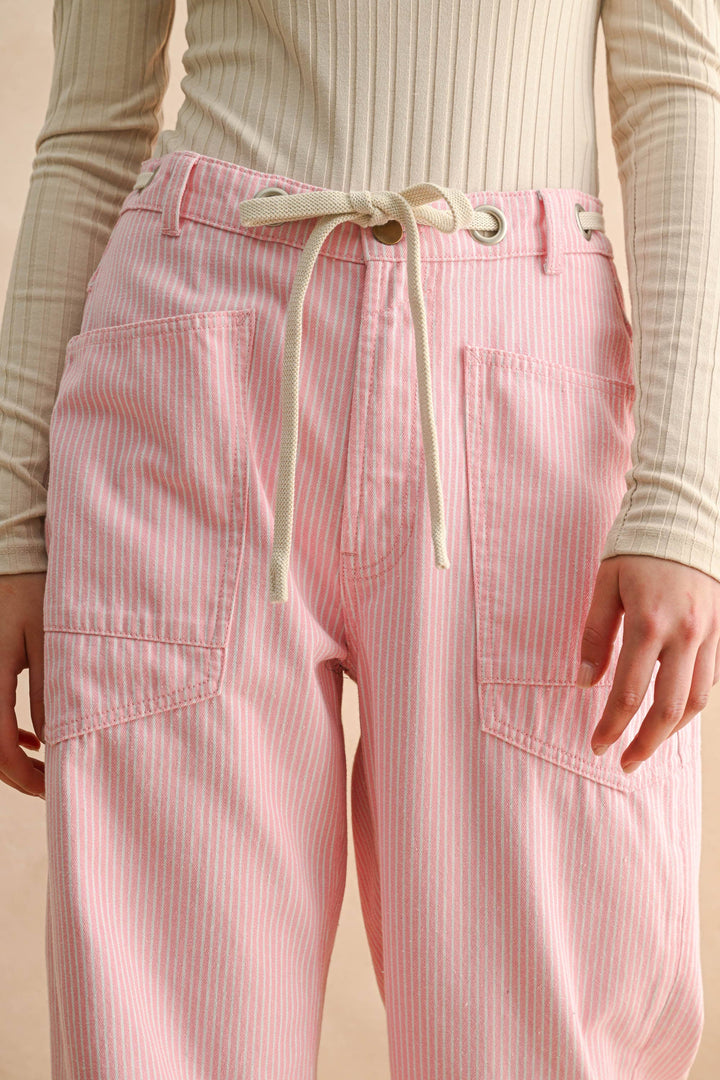 Woman wearing pink striped pants with drawstring waistline and utility pockets