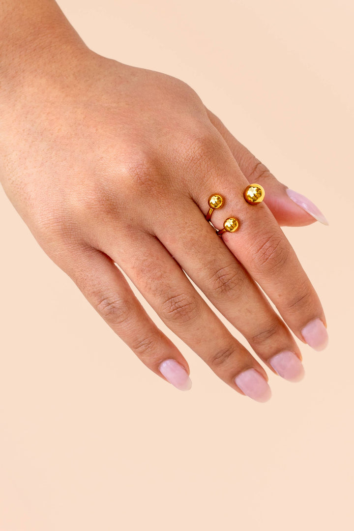 Hand wearing gold ring with spherical beads detail 