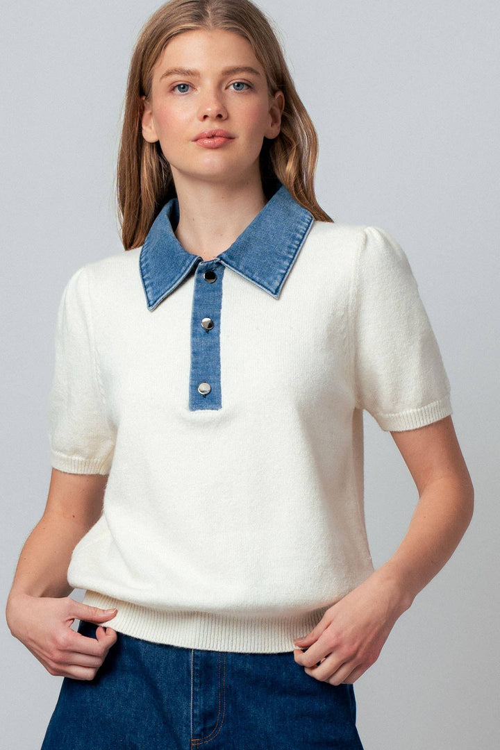 Woman wearing a white sweater with a blue denim collar against a gray background