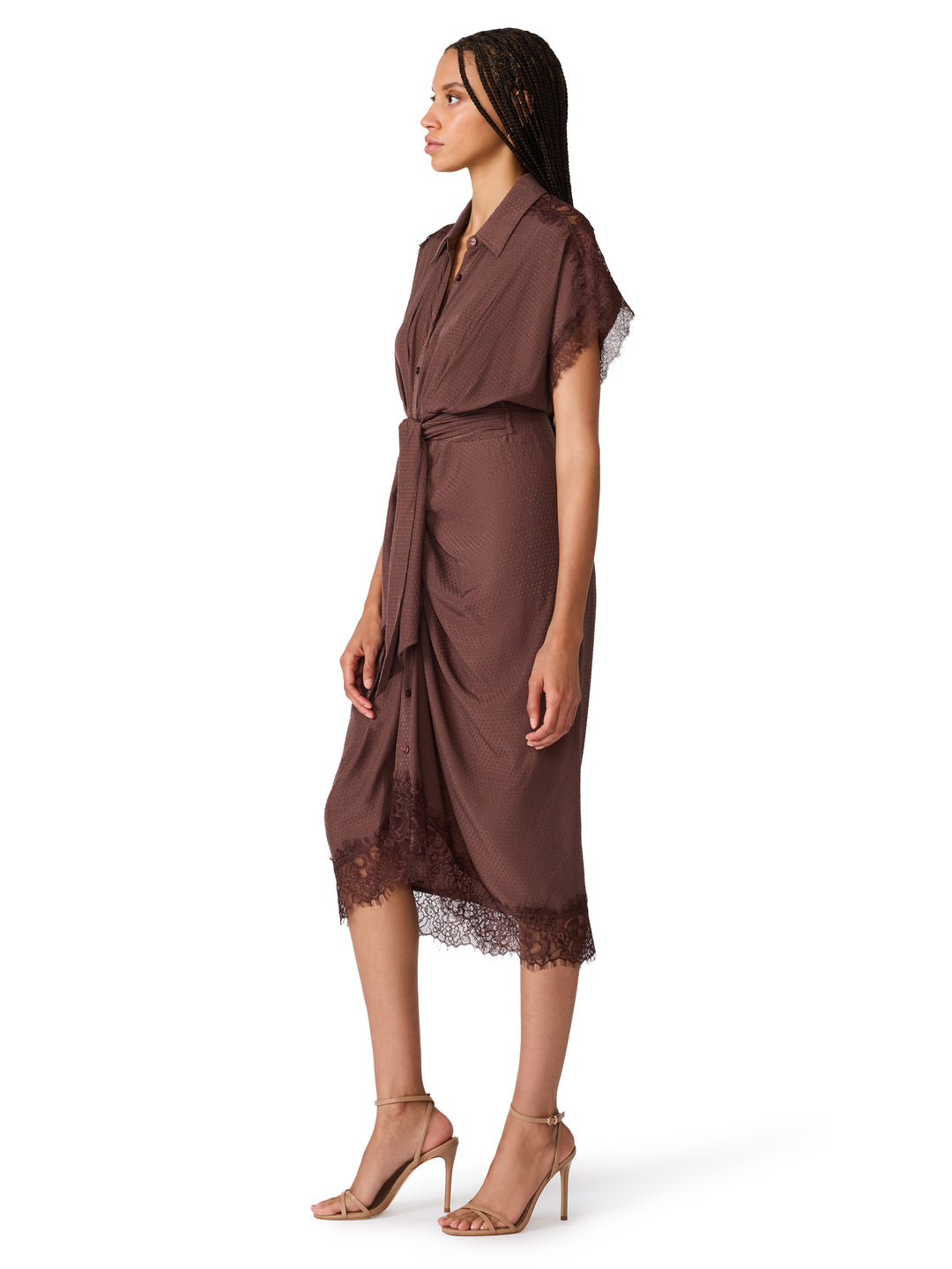 A woman modeling a brown wrap-style midi dress with sheer flutter sleeves, lace trim at the hem, and nude high-heeled sandals against a plain white background.