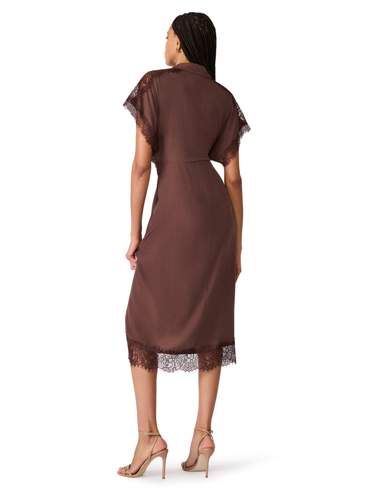 A woman shown from the back wearing a brown midi dress with sheer short sleeves and lace trim at the shoulders and hem, paired with nude high-heeled sandals against a plain white background.