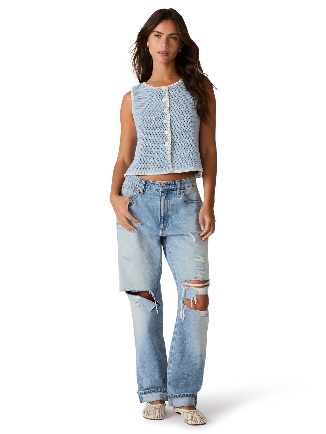 Woman wearing a sleeveless crochet button down sweater vest 