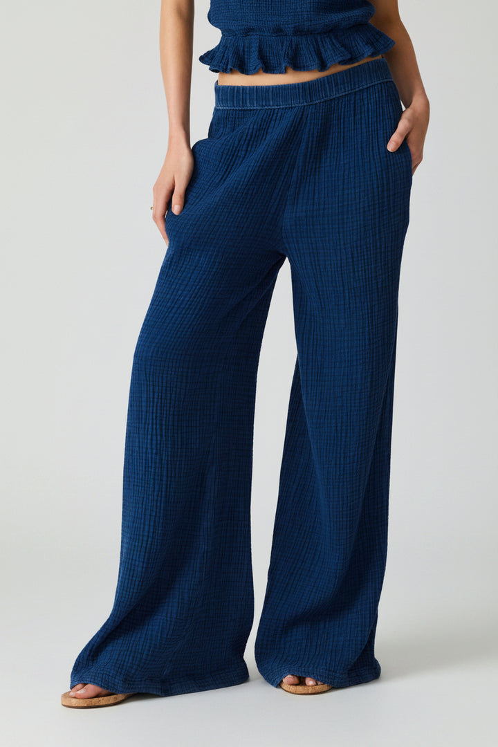Blue textured stretch waist pants worn by a woman on a white background