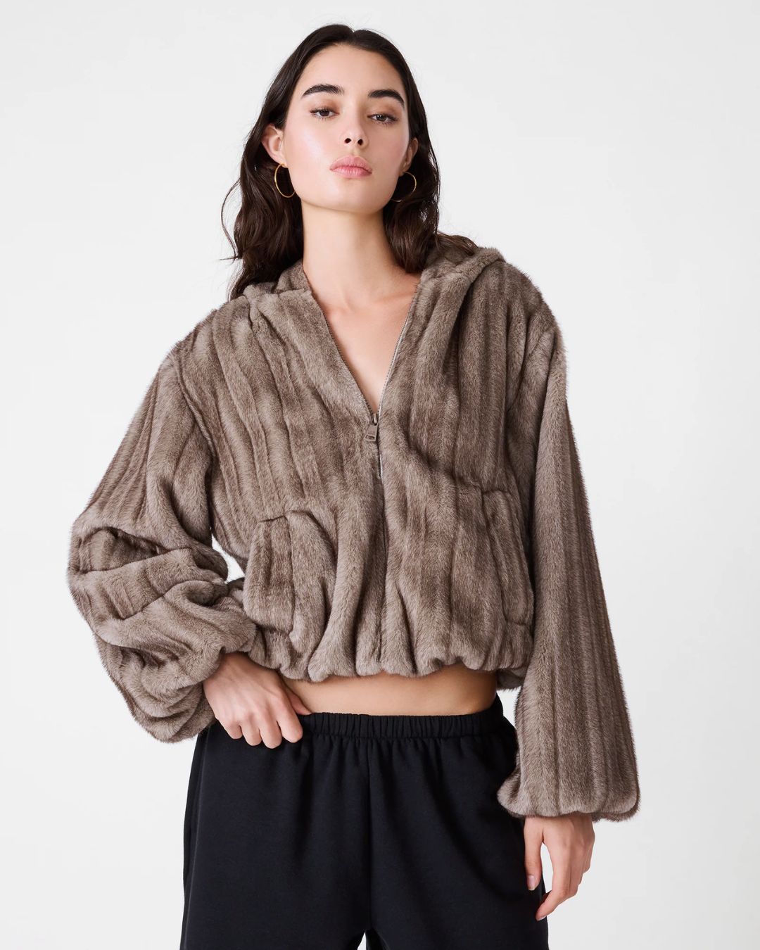 woman wearing gray faux fur zip up cropped jacket with hood
