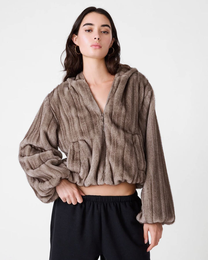 woman wearing gray faux fur zip up cropped jacket with hood
