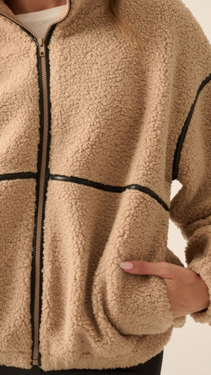 Light brown colored faux sherpa fleece jacket with faux black leather trim.