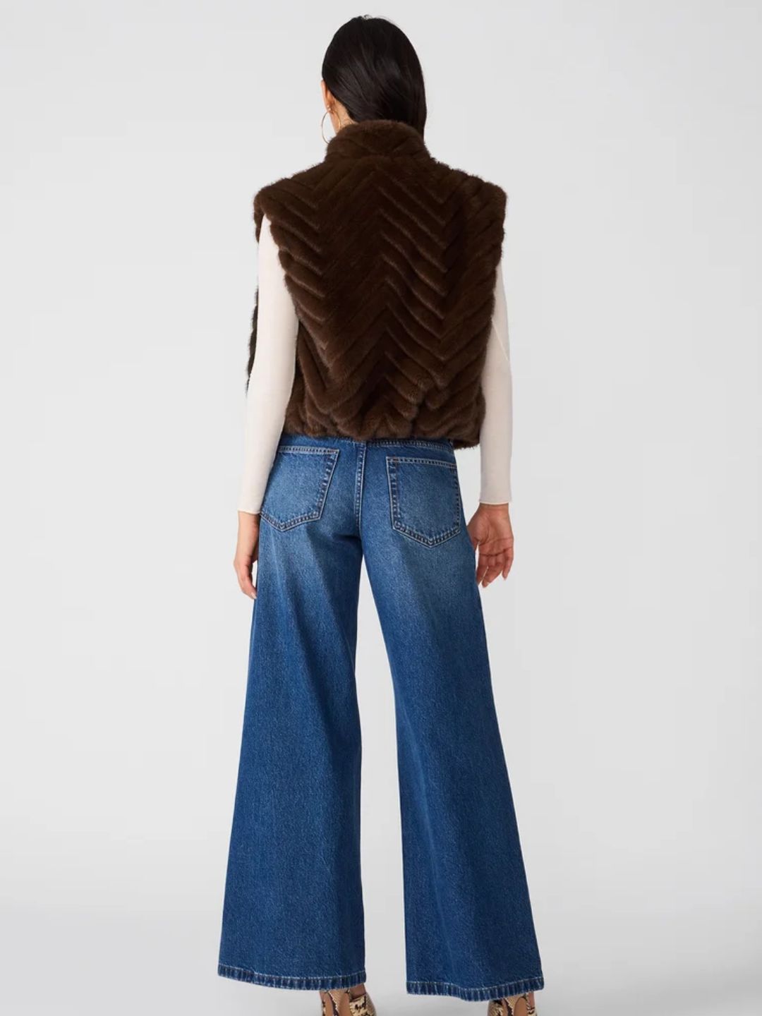 Woman wearing plush faux fur outerwear vest in dark brown