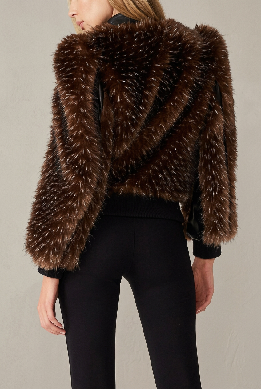 Woman wearing dark brown faux mink winter jacket with faux leather trim