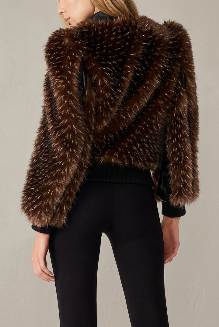 Woman wearing dark brown faux mink winter jacket with faux leather trim