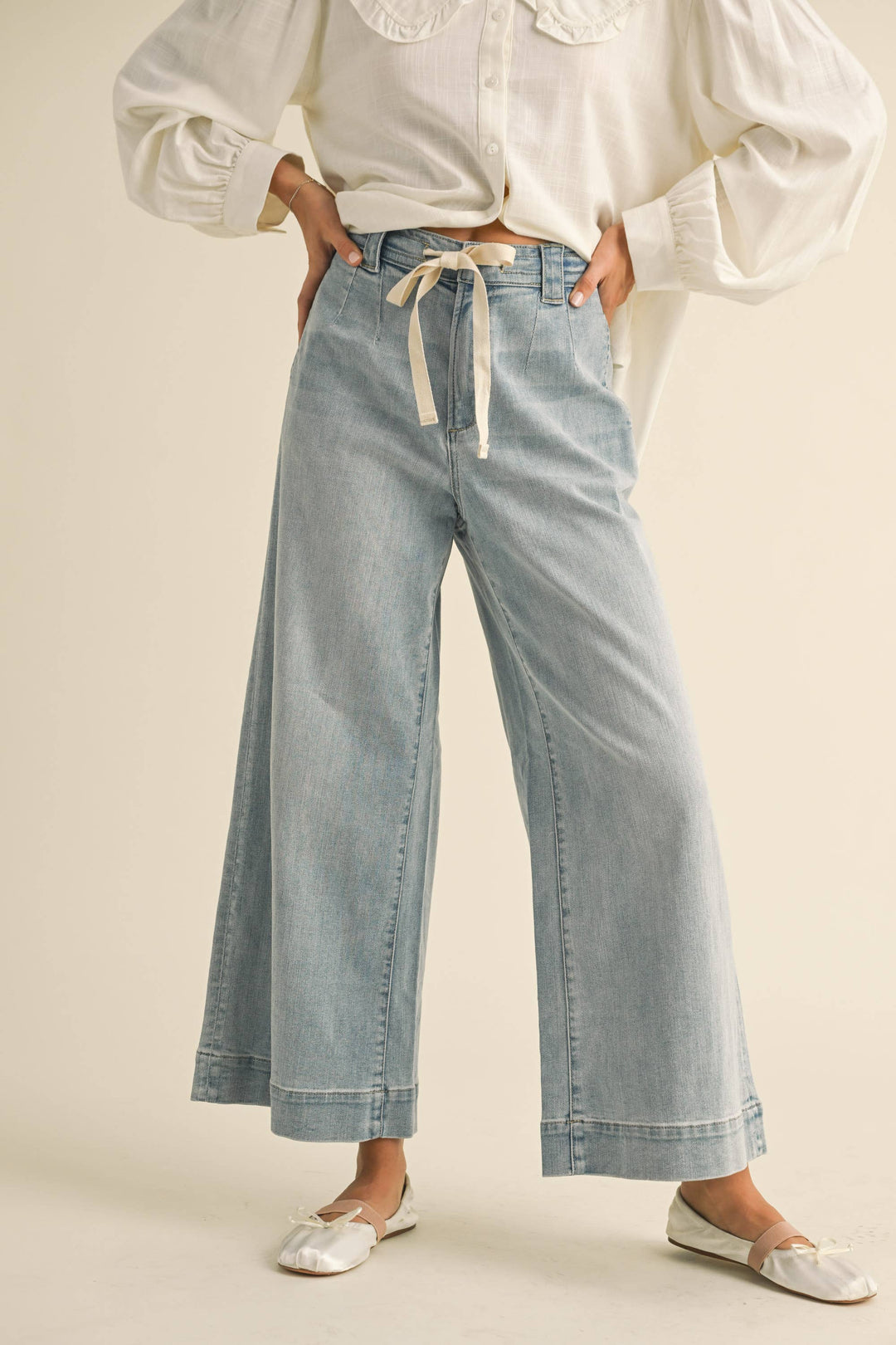 Woman wearing washed light blue denim pants with drawstring waist